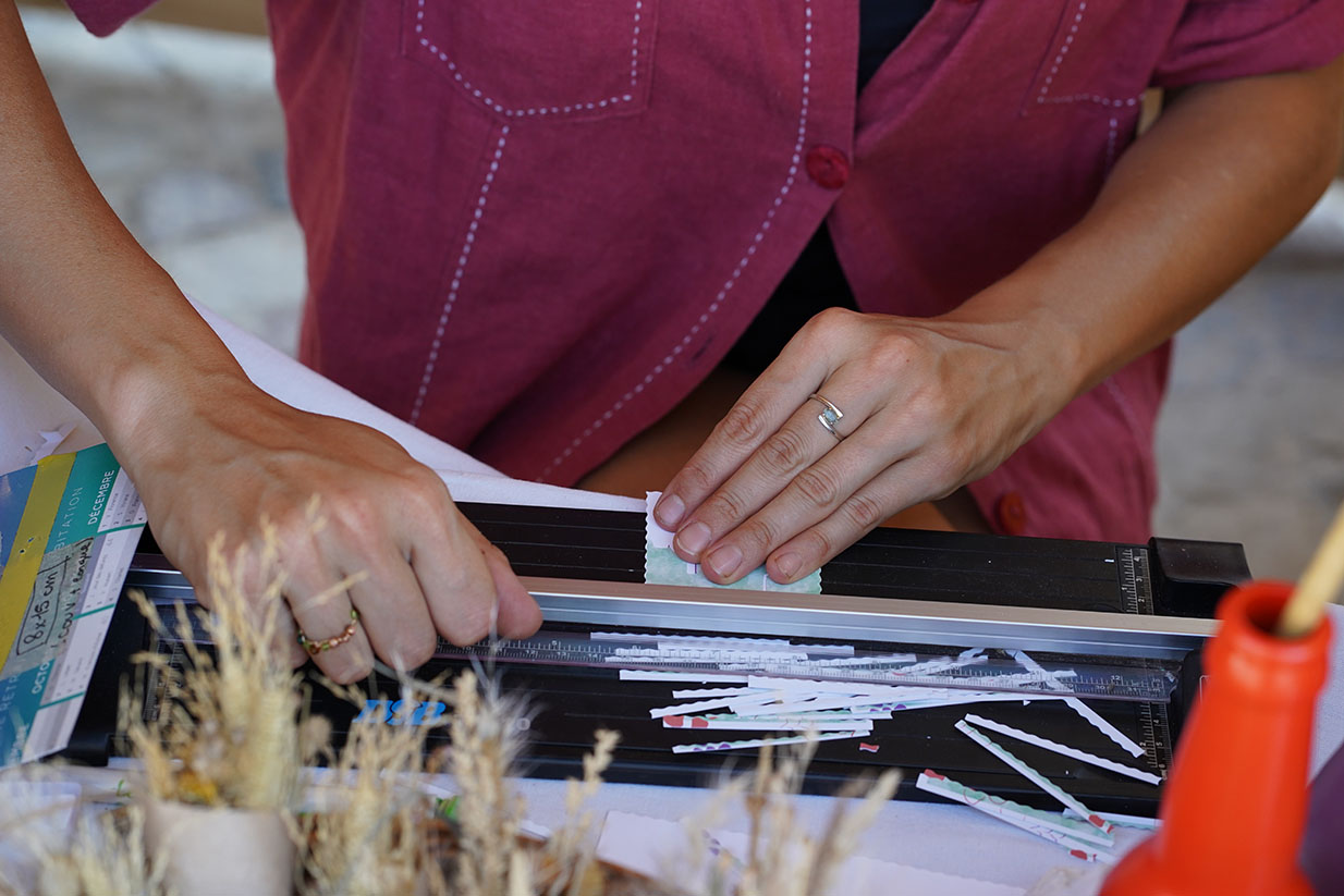 Artisan qui coupe des cartes de visites sur un massicot lors d'ateliers créatifs artisanaux