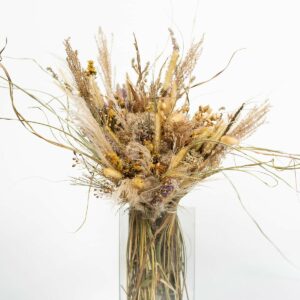 Gros bouquet de fleurs sauvages séchées dans un vase rectangulaire en verre transparent
