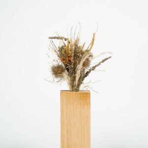 Moyen socle en bois fait main avec un bouquet de fleurs séchées
