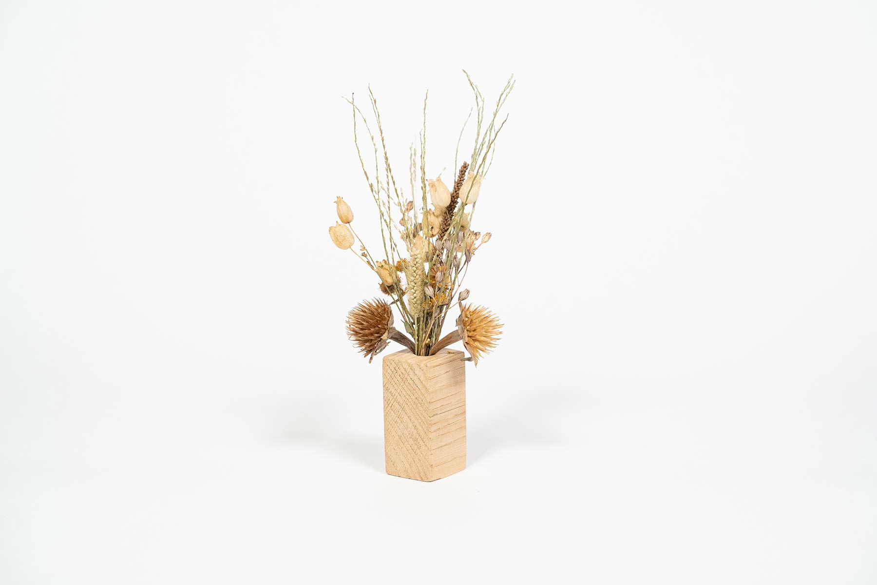 soliflore artisanal en bois contenant un petit bouquet de fleurs séchées