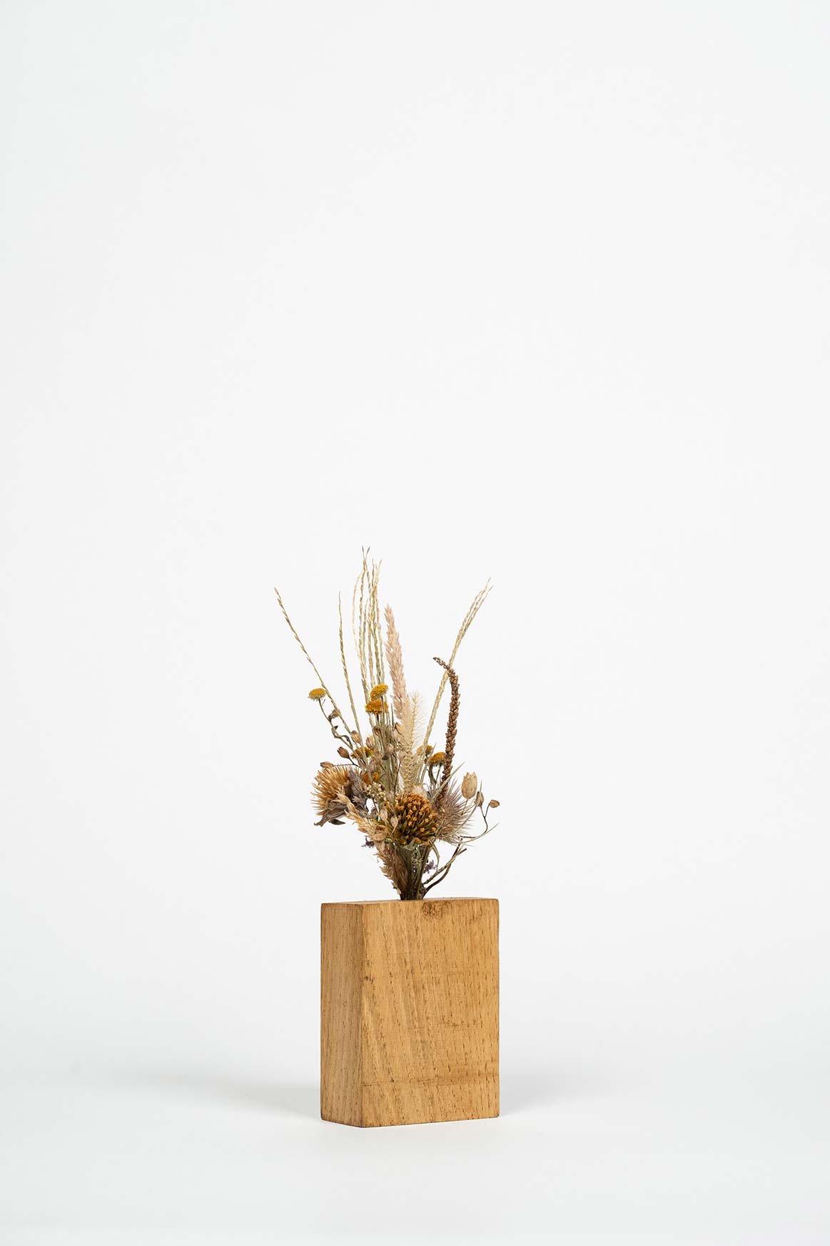 socle en bois fait main avec un mini bouquet de fleurs séchées