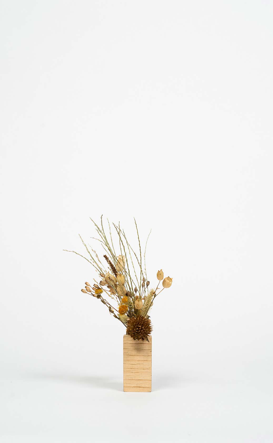 socle en bois artisanal avec un mini bouquet de fleurs séchées