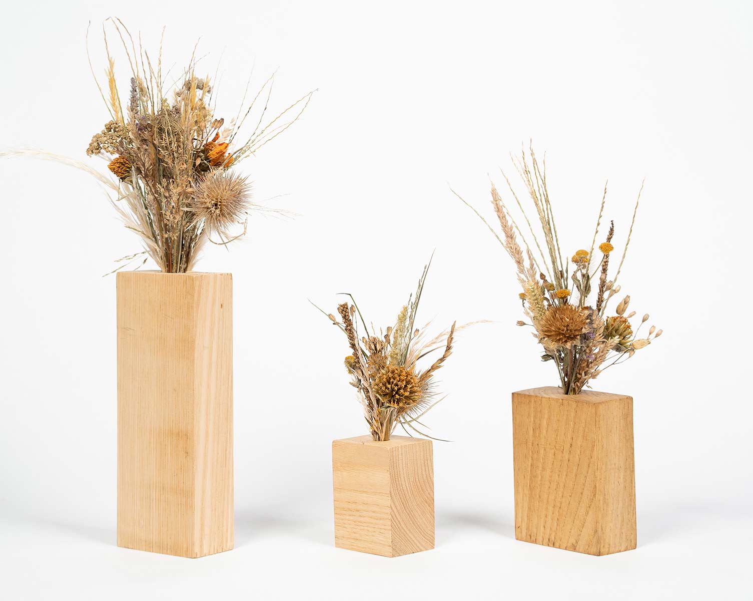 Trio de soliflores en bois contenant chacun un petit bouquet de fleurs séchées