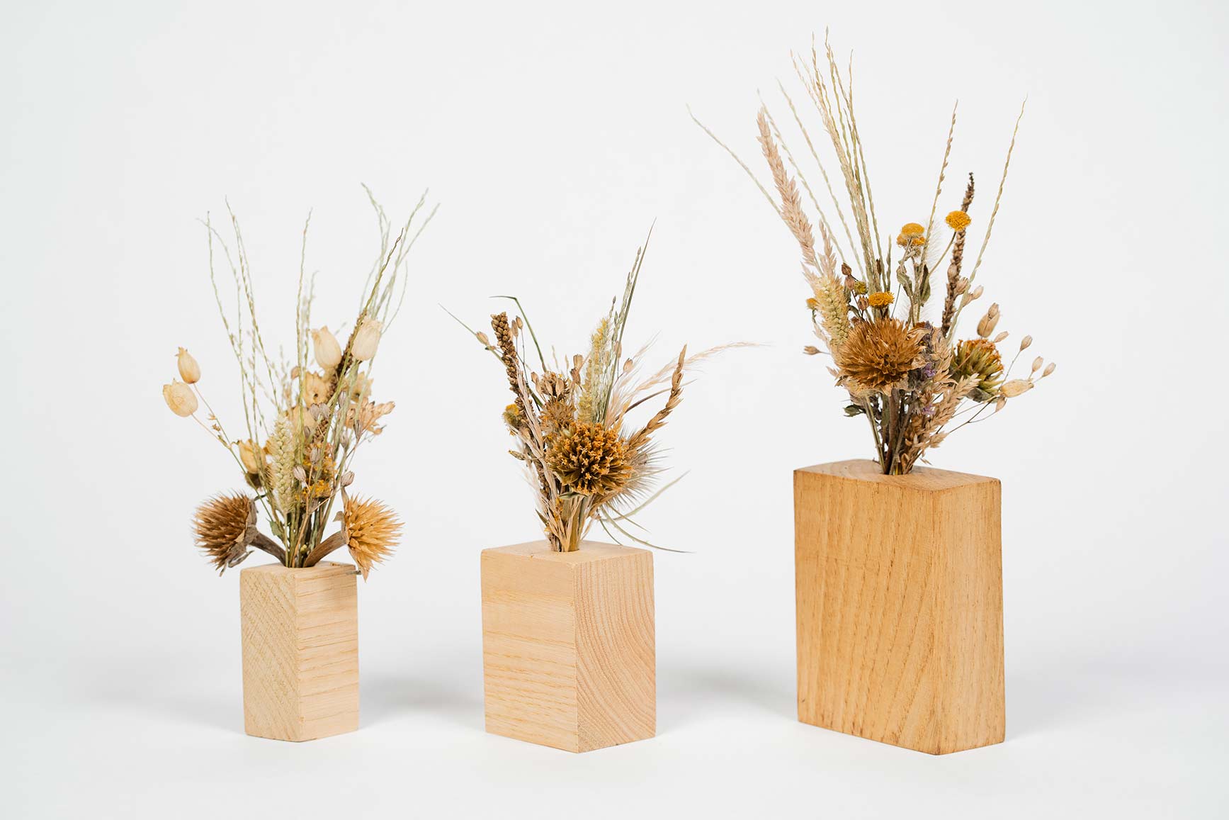 Trio de soliflores en bois contenant chacun des fleurs séchées