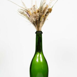 Vase en verre type gross bouteille verte contenant un bouquet de fleurs séchées