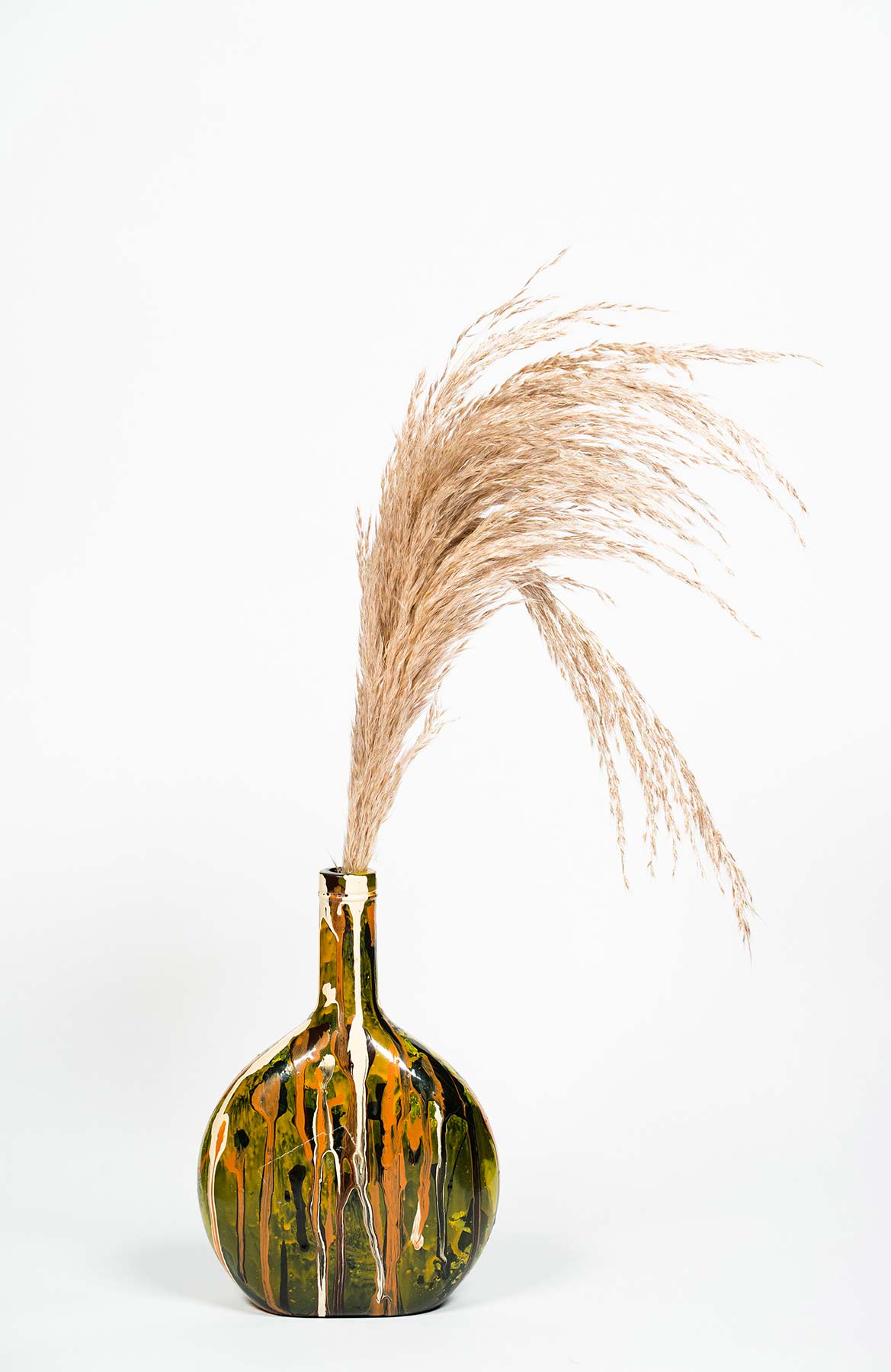 Vase original peint à la main contenant des fleurs séchées type pampas