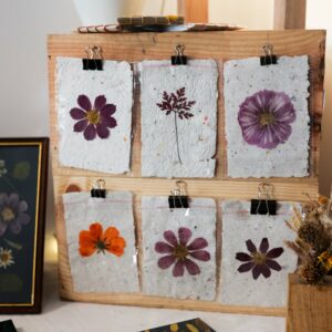 Stand de marche de createur avec plusieurs herbiers de fleurs pressees